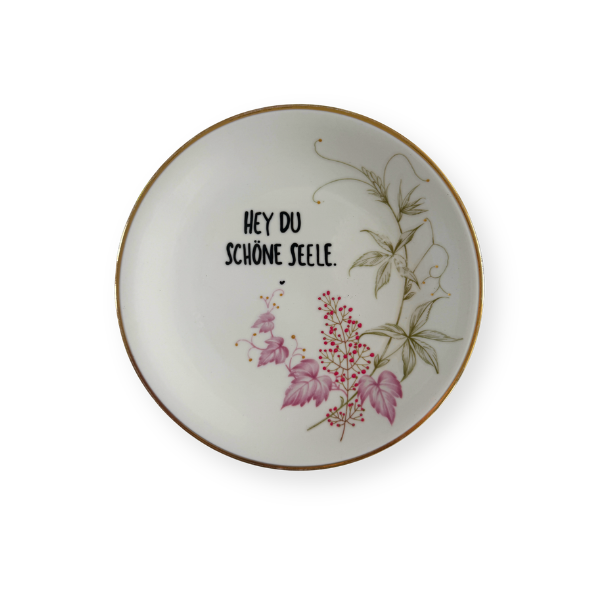 Cremeweißer Vintage Wandteller mit feinem Goldrand und handgeschriebenem Spruch „HEY DU SCHÖNE SEELE“.